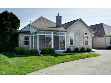 Beautiful sunroom featuring sliding windows, brick chimney, and a landscaped yard at 5839 Quail Run Dr, Indianapolis, IN 46237