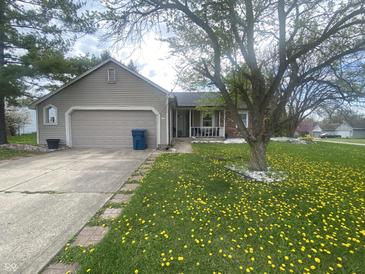 Charming ranch-style home featuring a well-maintained lawn, attached garage, and inviting front porch at 6011 Mcclellan Ct, Indianapolis, IN 46254