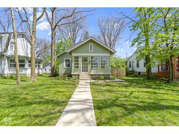 Charming green home with a bright sunroom and a well-maintained lawn at 6307 Broadway St, Indianapolis, IN 46220