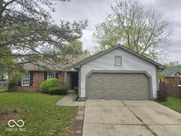 Charming single-story home with a brick facade, grey siding, and a well-manicured lawn at 9118 Lansburgh Ct, Indianapolis, IN 46234
