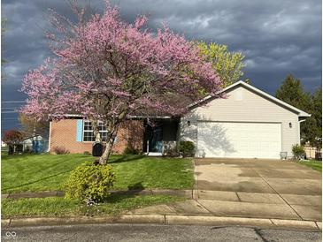 Charming home with a lush green lawn and beautiful flowering tree in the front yard at 1102 Branifield Ct, Franklin, IN 46131