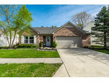 Charming single-story brick home with a two-car garage, a well-kept lawn, and beautiful landscaping at 12210 Doncaster Ct, Fishers, IN 46037