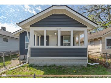 Charming exterior of home with siding, a covered porch with white accents, and the house number above the door at 1627 Lawton Ave, Indianapolis, IN 46203