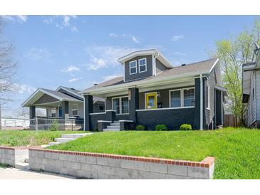 Charming home featuring a bright yellow door and a well-maintained front yard at 1835 N Rural St, Indianapolis, IN 46218