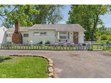 Charming single-story home with white siding, brick chimney, and a small picket fence at 219 S Sherman Dr, Indianapolis, IN 46201
