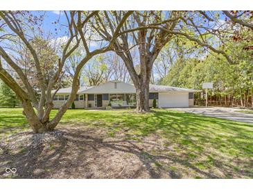 Ranch-style home with stone and painted brick, mature trees, well-maintained lawn, and attached two car garage at 2325 Melody Ln, Anderson, IN 46012