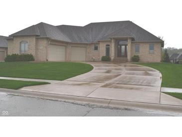 Elegant brick home featuring a well-manicured lawn and a concrete driveway leading to a spacious two-car garage at 5361 Ashby Ct, Greenwood, IN 46143