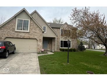 Charming brick home featuring a two-car garage, well-manicured lawn, and mature trees at 5640 Dapple Ct, Indianapolis, IN 46228