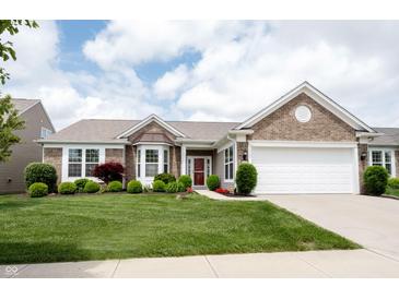 Charming brick home with manicured lawn, lush landscaping, and a two-car garage at 16204 Oakford Trl, Fishers, IN 46037