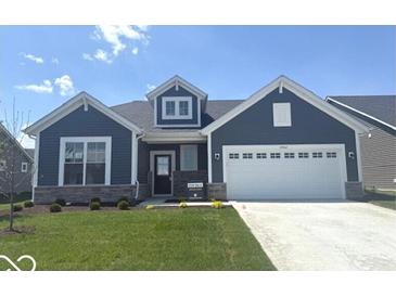 Charming blue house with a two-car garage, well-manicured lawn, and inviting front porch at 19774 Highclere Ln, Sheridan, IN 46069
