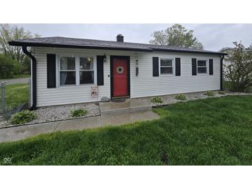 Charming single-story home with a red front door, black shutters, and manicured landscaping at 2650 Woodrow Ave, Indianapolis, IN 46241