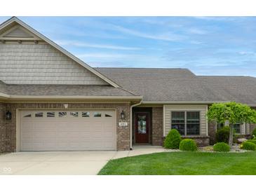 Charming brick home featuring a manicured lawn, attached two car garage, and covered entry way at 4061 Melbourne Dr, Columbus, IN 47203