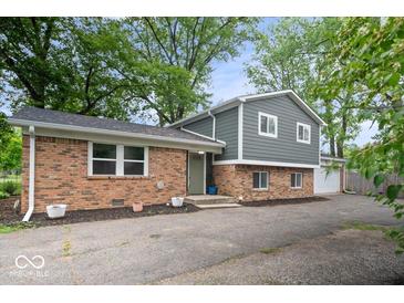 Charming exterior view of a two-story home featuring a brick facade, gray siding, and a well-manicured front yard at 5719 Laurel Hall Dr, Indianapolis, IN 46226