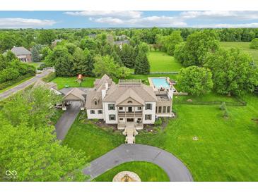 Expansive estate featuring a pool, lush landscaping, circular driveway, and a charming two-story residence at 6990 Old Hunt Club Rd, Zionsville, IN 46077