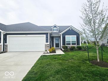 Charming single-story home with a two-car garage and a well-manicured lawn in a lovely neighborhood at 7141 Lillian Pl, Cumberland, IN 46229
