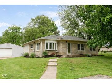 Charming single-story home featuring a stone facade, manicured lawn, and a walkway to the front entrance at 840 N Indiana St, Mooresville, IN 46158