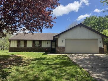 Charming single-story home with a well-maintained lawn and an attached two-car garage at 10569 Folsom Dr, Indianapolis, IN 46235
