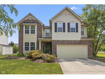 Charming home with brick and siding, a two-car garage, a manicured lawn, and colorful landscaping at 15936 Symphony Blvd, Noblesville, IN 46060