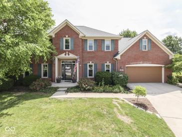 Charming two-story brick home featuring a landscaped yard, attached garage, and inviting entrance at 3601 Lakeshore Ct, Greenwood, IN 46143