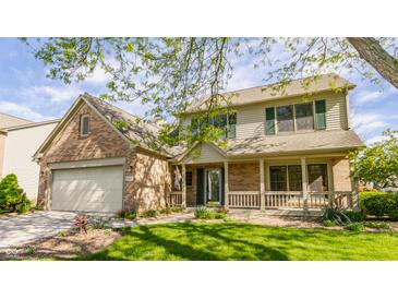 Inviting two-story home featuring a covered porch, brick accents, and well-manicured landscaping at 3808 Brigade Cir, Carmel, IN 46032
