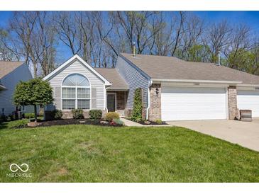 Charming home featuring an attached garage, well-maintained lawn, and lush landscaping at 5982 Blue Heron Way, Plainfield, IN 46168