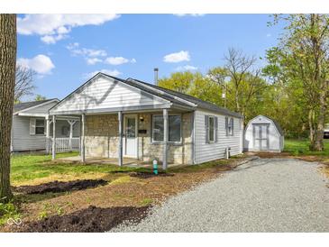Charming single-story home featuring stone accents, a covered porch, and a gravel driveway to a shed at 733 S Holmes Ave, Indianapolis, IN 46221