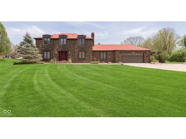 Beautiful brick two-story home with large lawn, red roof, and attached two car garage at 7901 Oaklandon Rd, Indianapolis, IN 46236