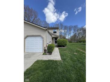 Charming home with a manicured lawn, walkway, and a bright, inviting exterior under a sunny sky at 9415 Timber View Dr, Indianapolis, IN 46250