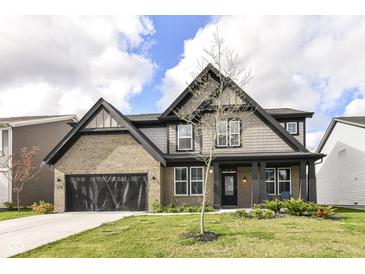 Charming two-story home with a brick and shingle exterior, black trim, and a well-manicured lawn at 9920 Deep Royal Way, Indianapolis, IN 46239