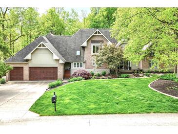 Beautiful two-story brick home with a well-manicured lawn and mature trees at 10919 Running Tide Ct, Indianapolis, IN 46236
