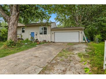 Charming single-story home with attached garage and a blue front door, nestled under mature trees at 150 Church St, Mooresville, IN 46158