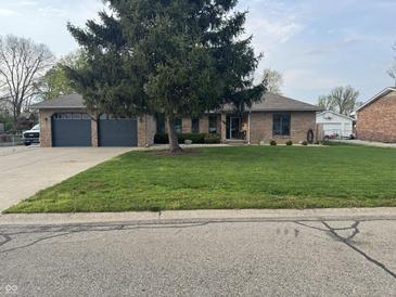 Charming brick home with a well-manicured lawn, mature tree, and a spacious two-car garage at 2550 16Th St, Columbus, IN 47201