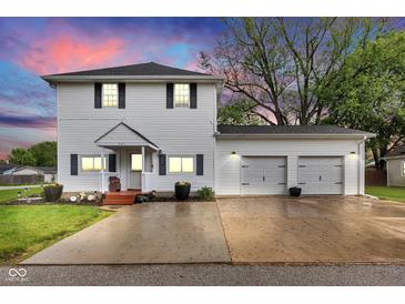 Charming two-story home featuring a two-car garage, a manicured lawn, and a cozy front porch at 301 S B St, Thorntown, IN 46071