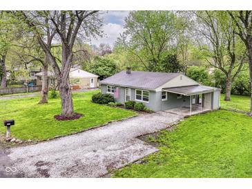 Aerial view of a cozy home with a spacious yard, carport, and gravel driveway at 5141 Annette St, Indianapolis, IN 46208