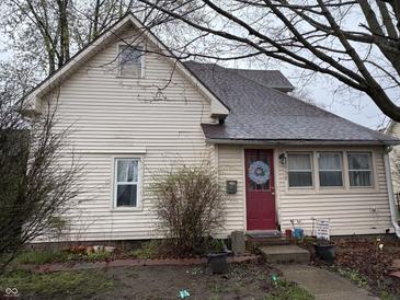 A cozy two-story home featuring light siding and a bright red front door with decorative wreath at 658 Chestnut St, Noblesville, IN 46060
