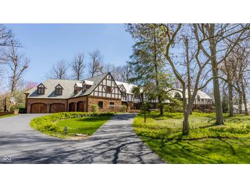 Charming Tudor-style home with a brick facade, slate roof, and a circular driveway at 8103 N Pennsylvania St, Indianapolis, IN 46240