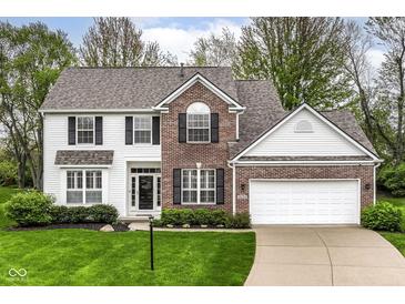 Charming two-story home featuring a brick and white siding facade and a well-manicured front yard at 10524 Hawks Ridge Ct, Fishers, IN 46037