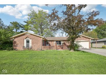 Charming brick home with attached garage and lush green lawn in a well-maintained neighborhood at 1416 Wellington Ave, Indianapolis, IN 46219