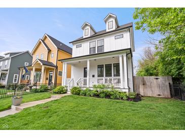 Charming white two-story home boasts a welcoming front porch and manicured lawn at 2044 Alvord St, Indianapolis, IN 46202