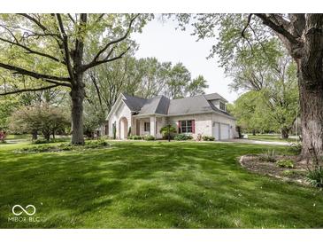 Stunning brick home with manicured lawn, mature trees, and three car garage at 1920 E 81St St, Indianapolis, IN 46240