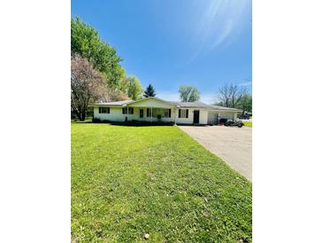 Charming single-story home featuring a well-manicured lawn and an attached garage with a spacious driveway at 2871 N Talley Rd, Columbus, IN 47203