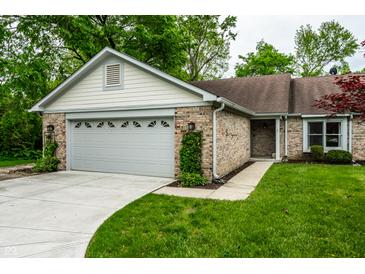 Charming single-story home features brick facade, attached garage, and a well-maintained front yard with mature trees at 5204 Whipple Wood Ct, Indianapolis, IN 46226