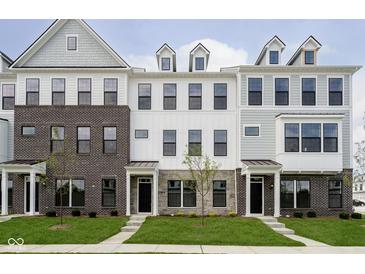 Modern townhomes with brick, stone, and siding exteriors and well-manicured lawns create an inviting curb appeal at 10959 Belgian Ln, Zionsville, IN 46077