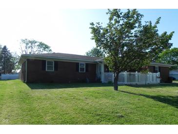 Single story brick home with a white picket fence and lush green lawn at 2630 Wedgewood Dr, Columbus, IN 47203