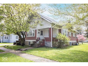 Charming craftsman-style home features red brick accents, a cozy front porch, and a well-manicured lawn with mature trees at 300 E 2Nd St, Sheridan, IN 46069