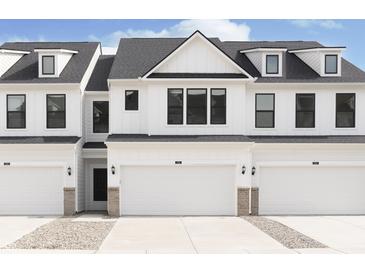 New construction townhome featuring a crisp white exterior, black trim windows, and a convenient two-car garage at 3305 Noriker Ln, Zionsville, IN 46077