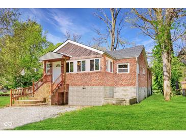 Charming brick home with a well-maintained yard, inviting entrance, and foundation at 7002 N Ralston Ave, Indianapolis, IN 46220