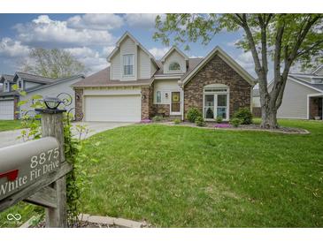 Charming two-story home with a brick facade, manicured lawn, and attached two-car garage at 8875 White Fir Dr, Indianapolis, IN 46256