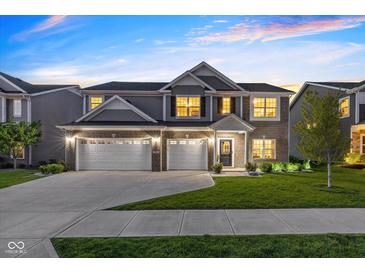 Charming two-story home with a three car garage, manicured lawn, and professional landscaping at 900 Parker Ln, Westfield, IN 46074