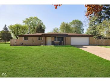 Charming ranch-style home featuring a spacious front yard, attached garage, and cozy front porch at 9748 W Sunset Ln, Elwood, IN 46036